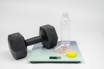 Weight scales and dumbbells isolated on white background