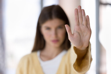 Close up focus young woman show palm, stretch her hand to camera, express opinion against gender...