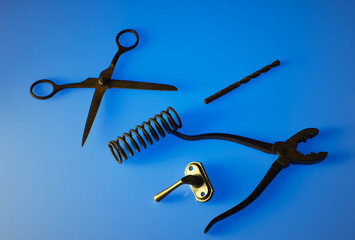 A set of vintage, patina-coated metal objects on a blue background