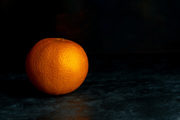 Ripe sweet orange. Fresh organic fruit on black background. Dark low key photo. Copy space....