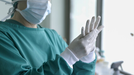 Doctor putting on surgical gloves , professional medical safety and hygiene for surgery and medical...