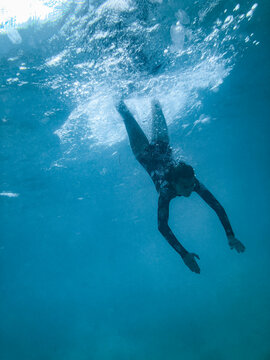 Female underwater in ocean wearing full piece swimsuit