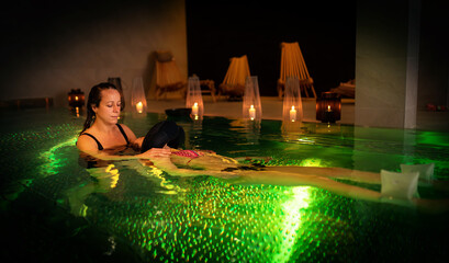 Therapeutic exercise in the pool. Woman receiving an aquatic therapy in the pool. Water relaxation and deep meditation.
