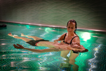 Therapeutic exercise in the pool. Woman receiving an aquatic therapy in the pool. Water relaxation...