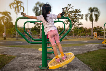 A cute girl  having fun on the swing at the playground.