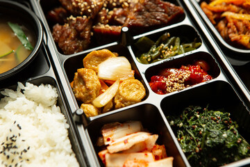 Beef bulgogi and various side dishes in a packaging container