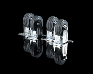 Rubber wheels in a metal frame on a black background with a reflection on the table.