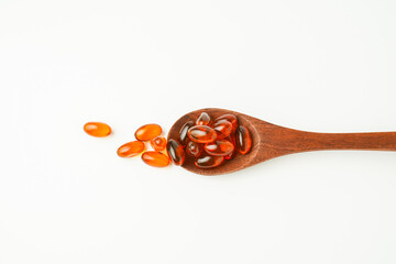 softgel in a spoon, Close up of oil filled capsules, suitable for presenting food supplements : fish oil, omega 3, omega 6, omega 9, vitamin A, vitamin D, vitamin D3, vitamin E, evening primrose oil