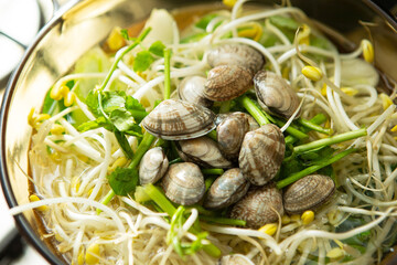 Clear clam soup boiling with vegetables in a pot	