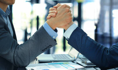 Two businessmen press hands each other on a forward background