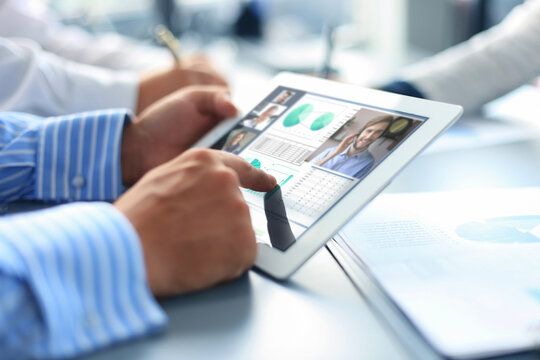 People meeting analyzing financial statistics in office. Group of business team having video conference with their team on digital tablet, remote work at home.
