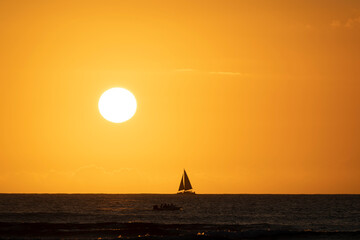 日没イメージ　海に沈む夕日とヨットのシルエット © apiox