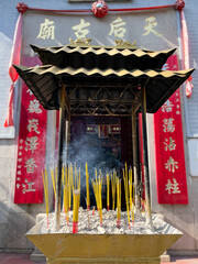 Burning incense with White Smoke and Chinese Temple in the Background