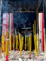 Burning incense with White Smoke and Chinese Temple in the Background