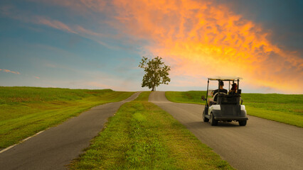 Golf cart in motion in a beautiful park. Driving on rural road at sunset, motion blur