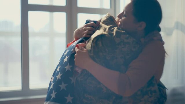 Happy American woman hugging military husband returning home from hot zone