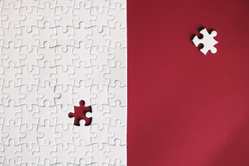 Clean puzzle elements on the red background. Empty puzzle piece on the table. Teamwork concept.