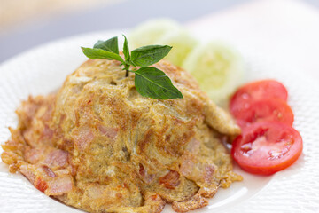hai Style Omelet with Bacon on Rice Side dishes is cucumber and tomato on blur Background Closeup