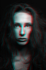 Sci-fi and fashion concept. Studio portrait of beautiful woman in red and blue color split effects. Model with long and dark dreadlocks looking at camera with seductive look. Futuristic looking style