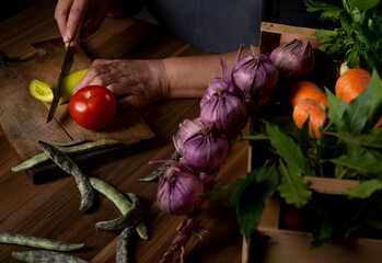 woman cutting vegetables on wooden board