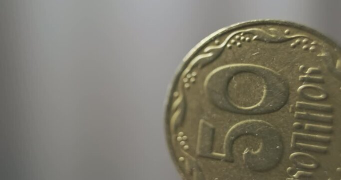 Yellow Ukrainian coin, 50 kopecks. Close-up, macro shot. Panorama of the tails side of the coin.