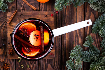 A white ladle with boiled mulled wine stands on a wooden table
