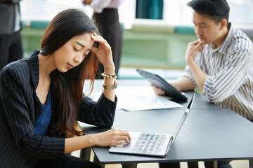 businesswoman feeling tired from overworked with laptop computer on the table
