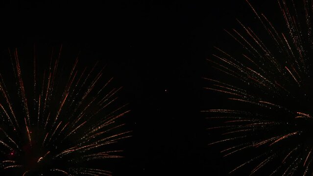 Colorful fireworks festival. Beautiful fireworks close-up view in slow motion. Wonderful real fireworks in the night sky shot with a telephoto lens. fireworks show. 4K slow motion video.