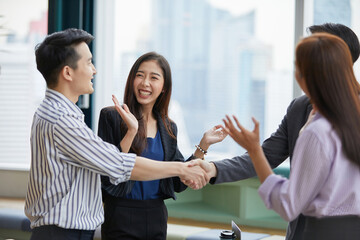businesspeople shaking hands and clapping hands for celebrating success at work in the office