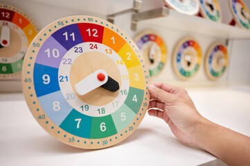 Daylight saving time or Time management concepts. Male hand holding colorful wooden clock on home...