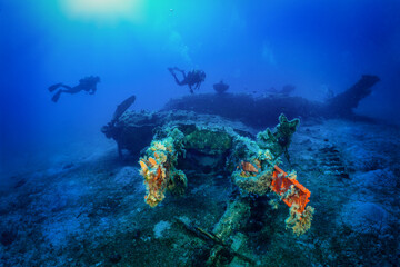 Fototapeta na wymiar A scuba diver explores a sunken world war two fighter propeller airplane at the seabed of the Aegean Sea, Naxos island, Greece