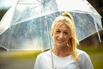 Woman girl in portraits in a t-shirt under an umbrella in the rain, hair blond and piercings in the...