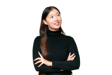 Young Asian woman over isolated chroma key background looking up while smiling