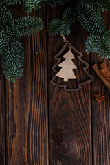 New Year's background. Wooden boards, branches of nobilis and wooden decorations in the form of Christmas trees