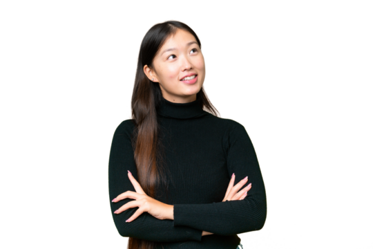 Young Asian woman over isolated chroma key background looking up while smiling
