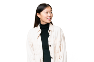 Young Asian woman over isolated chroma key background looking to the side and smiling