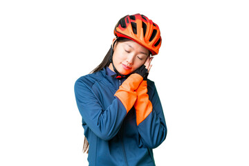 Young cyclist woman over isolated chroma key background making sleep gesture in dorable expression