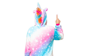 Young Asian woman with unicorn pajamas over isolated chroma key background pointing back with the index finger