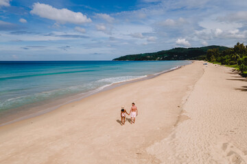 Drone view at a couple walking on the beach of Karon Phuket Thailand during vacation - Powered by Adobe