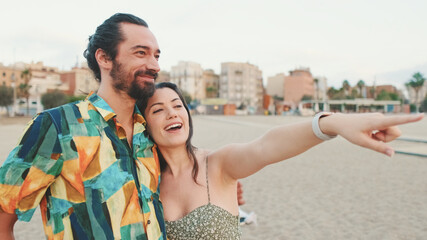 Newlyweds hug and talk while standing on the coast