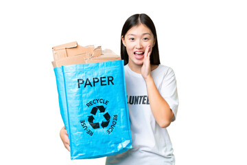 Young Asian woman holding a recycling bag full of paper to recycle over isolated chroma key background shouting with mouth wide open