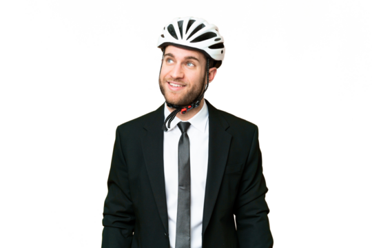 Business person with a bike helmet over isolated chroma key background thinking an idea while looking up
