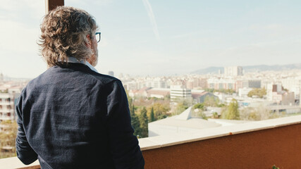 Senier enjoys the view standing on the balcony