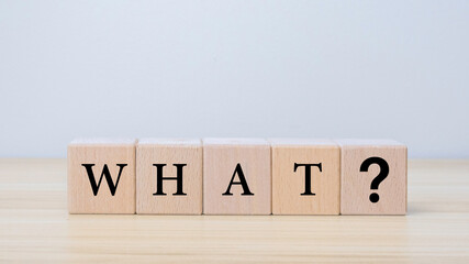 Question "what" word with black wooden cube on wooden table background. Frequently Asked Questions and Answer Ideas