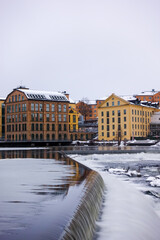 Obraz premium The river Motala Ström (Strömmen) by old industrial buildings, a landmark of Norrköping, Sweden