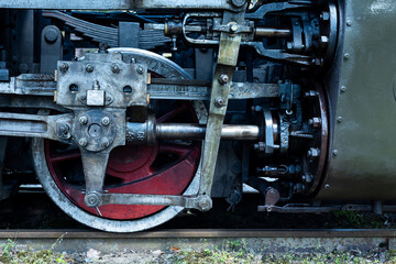 A close-up of a steam locomotive's propulsion system. Steam locomotive standing on the tracks, photo taken in natural lighting conditions.