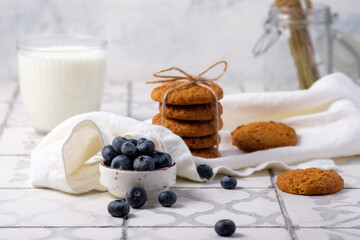 Fresh grandmother's oatmeal cookies with milk and berries on a linen napkin in the village.