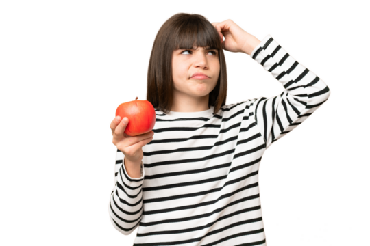 Little girl with an apple over isolated chroma key background having doubts and with confuse face expression