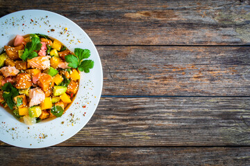 Salmon ceviche with lemon, mango and avocado on wooden table