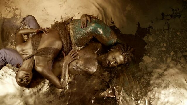 A magical couple lying in liquid gold a mermaid and a shaman as in a psychedelic dream
